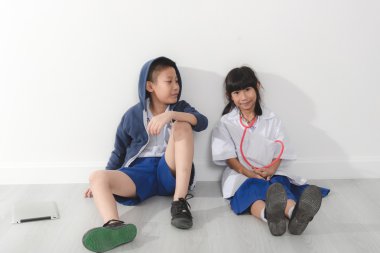 Asya genç doktor ve hasta oturan gri zemin ve beyaz w