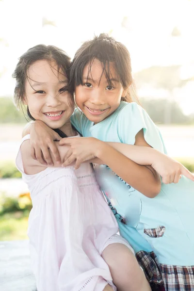 Счастливые дети обнимают друг друга и улыбаются в камеру — стоковое фото