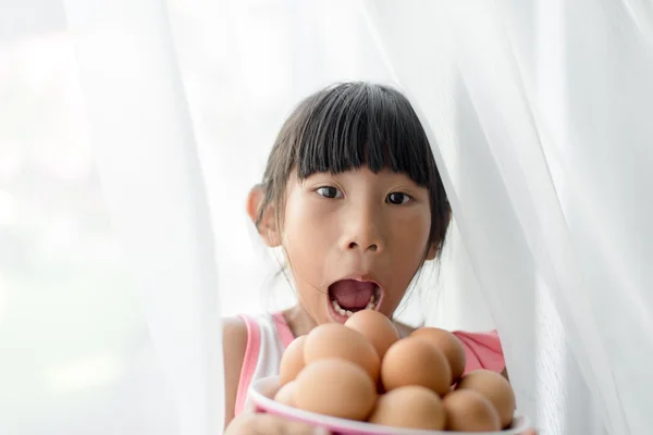 Sorprendente ragazza in possesso di uova ciotola con tenda bianca — Foto Stock
