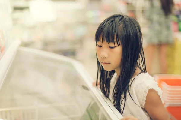Asian girl in front of sweet candy food store window, colour eff — Stock Photo, Image