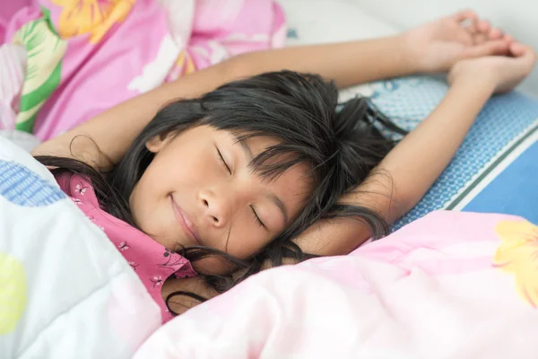 Aziatisch meisje slapen op bed bedekt met deken — Stockfoto