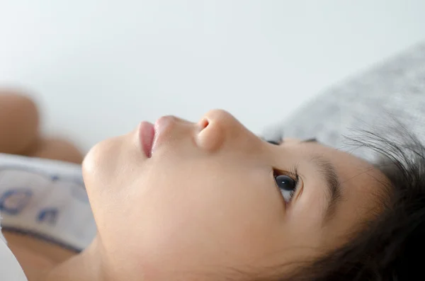 Gesloten op leuke Aziatische meisje ontspannen op bed thuis met copyspace — Stockfoto