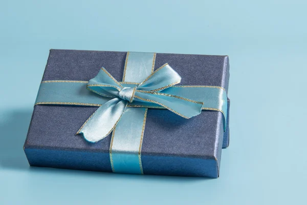 Modrá dárková krabička na modré barvy pozadí — Stock fotografie