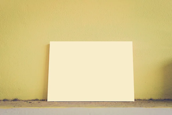 Mock up paper display on dirty and yellow wall in vintage style. — Stock Photo, Image