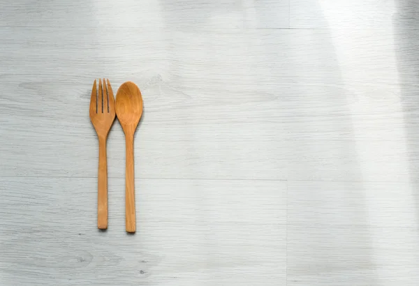 Achtergrond van een houten lepel en vork op grijze houten vloeren — Stockfoto