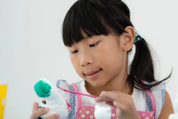Aziatische kind schildert de kleuren van wit gips doll speelgoed op de — Stockfoto