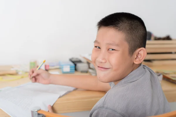 Азиатский мальчик делает домашнее задание дома — стоковое фото