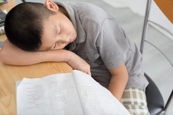 Asian child of primary school age do homework. The boy does his — Stock Photo, Image