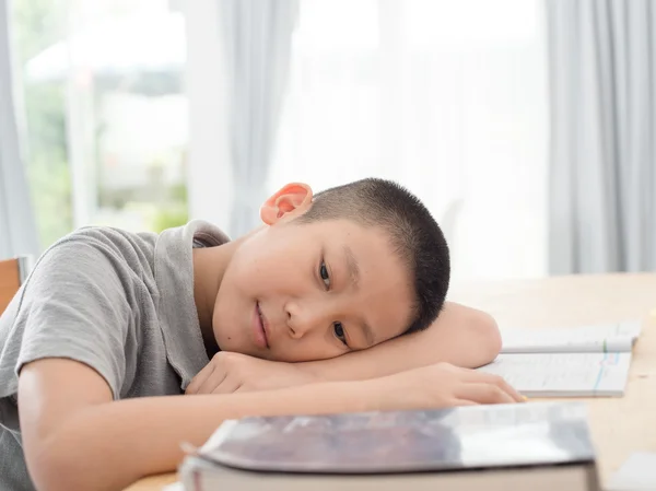 Un enfant asiatique en âge d'aller à l'école primaire fait ses devoirs. Le garçon fait le sien — Photo