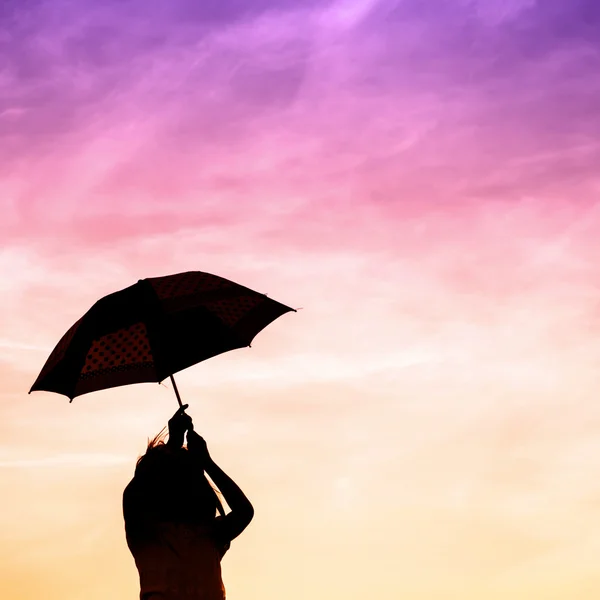 Bewegingsonscherpte springen paraplu meisje met zonsondergang silhouet, kopie s — Stockfoto