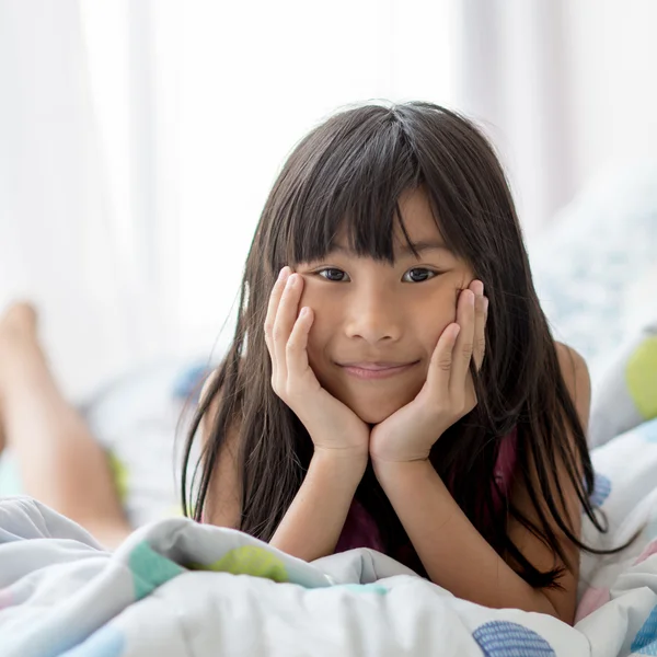 Leuke Aziatische meisje tot op bed met natuurlijke lichtinval thuis. — Stockfoto