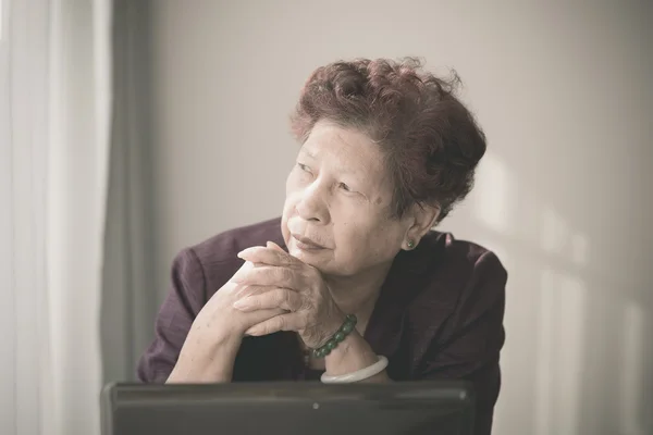 Asijské starší žena učí notebook doma a podívejte na — Stock fotografie