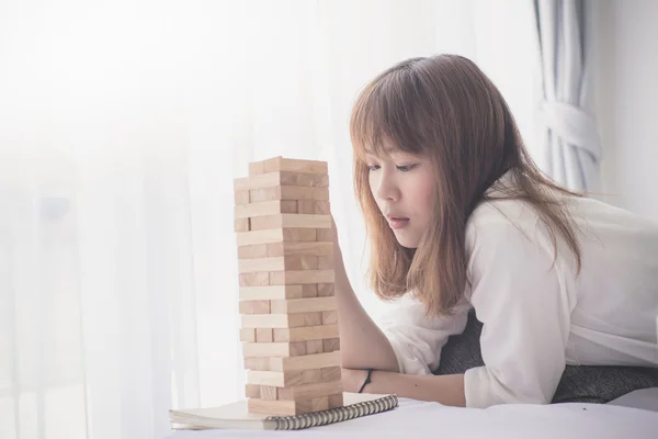 Asiatische Teenager spielen Holzblock mit Fenster Licht Hintergrund — Stockfoto