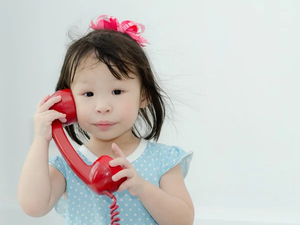 Asyalı kız kırmızı retro telefon evde oynarken — Stok fotoğraf