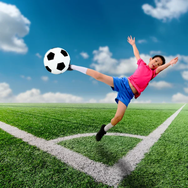 Motion blur băiat asiatic cu minge de fotbal la terenul de fotbal și albastru — Fotografie, imagine de stoc