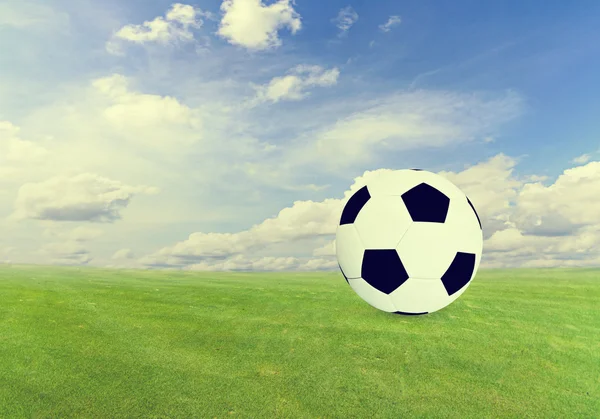 Soccer ball on  green field with blue sky — Stock Photo, Image