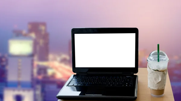 blank screen laptop on table and blur cityscape background backg