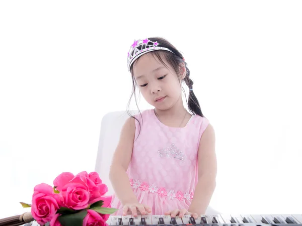 Asian girl in princess dress playing keyboard on white. — Stock Photo, Image