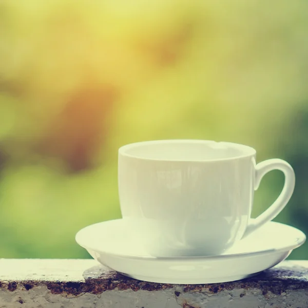 Beyaz kahve fincanı yeşil bokeh ile. — Stok fotoğraf