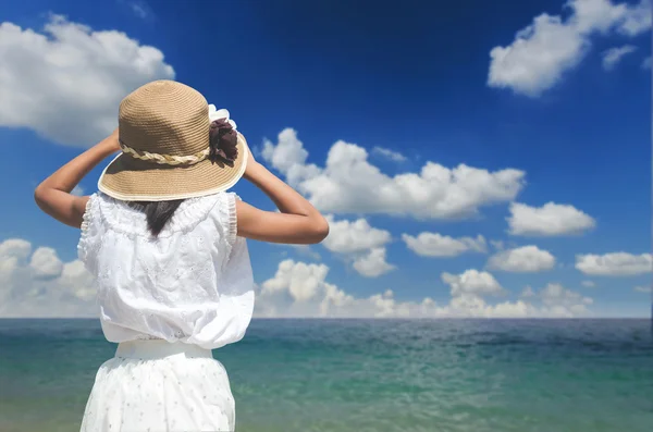 Indietro di ragazza indossando cappello con nuvola di sfondo e cielo e mare a — Foto Stock