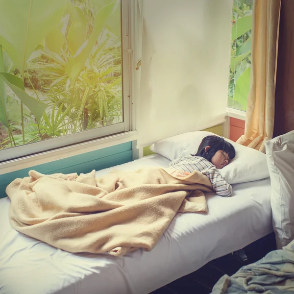 Asian girl sleeping on bed covered with blanket. — Stock Photo, Image