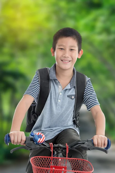 Chłopiec azjatyckich z plecaka, jazda na rowerze, na białym tle na backgro charakter — Zdjęcie stockowe