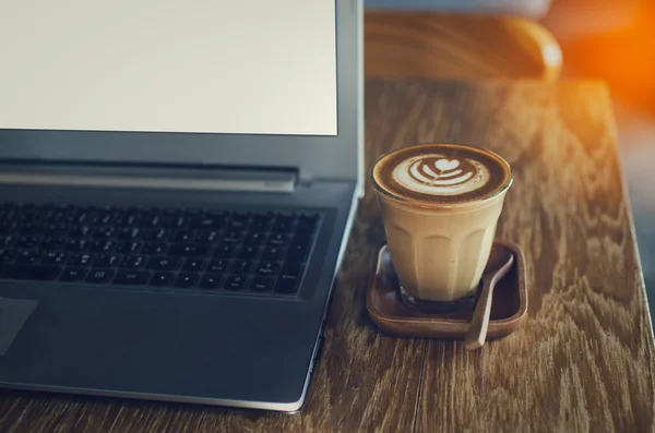 Кофейная чашка и ноутбук для бизнеса, выборочный акцент на кофе и — стоковое фото