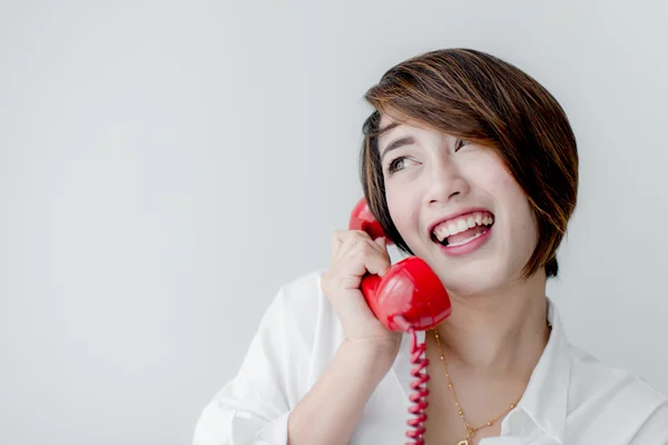 Attraente asiatico donna utilizzando rosso retrò telefono — Foto Stock