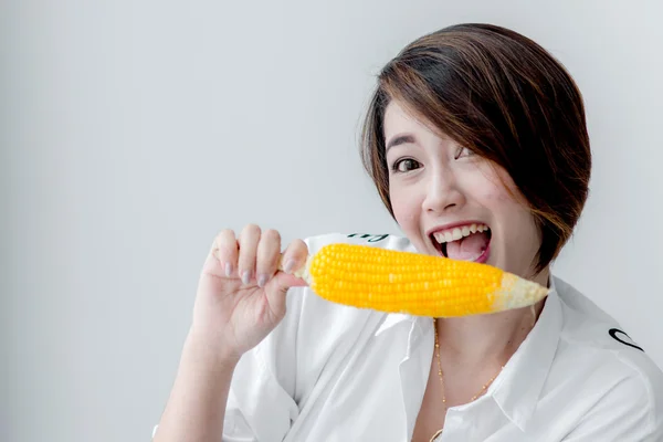 Asian girl eating yellow corn at home. — Stock Photo, Image