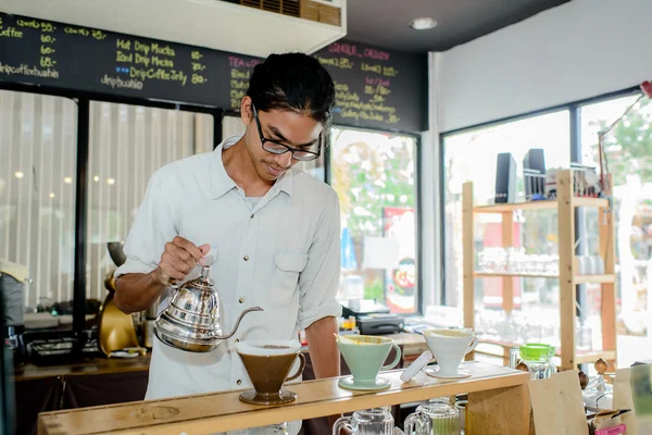 Camarero joven haciendo una taza de café en la cafetería —  Fotos de Stock