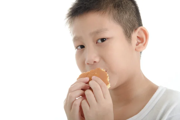 Азиатский мальчик ест булочку дораяки на белом фоне . — стоковое фото