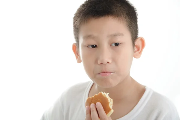 Ásia menino comer dorayaki bun no branco fundo . — Fotografia de Stock