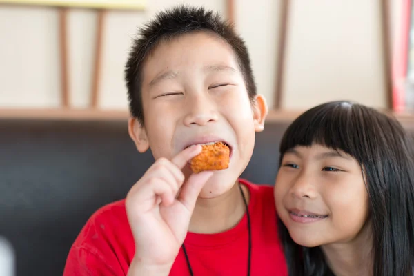 Gelukkige Aziatische kinderen eten fastfood — Stockfoto