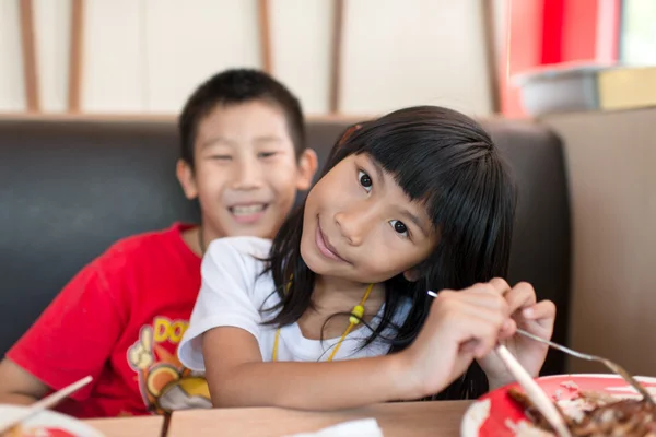 Happy Asian children eating fast food — Stock Photo, Image