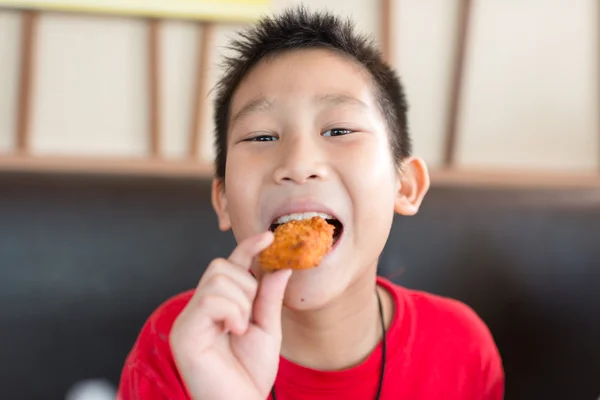 Happy Asian child eating fast food — Stock Photo, Image