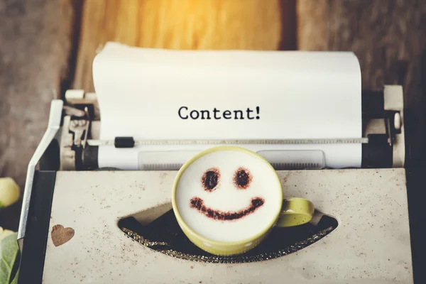 Máquina de escribir con taza de café cara feliz, tono sepia . — Foto de Stock