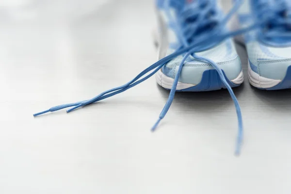 Selective focus close up blue sport shoes on gray floor. — Stock Photo, Image