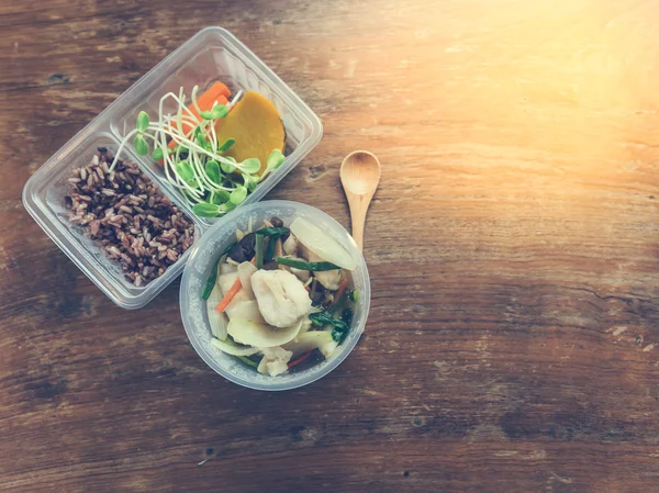 Здорова їжа в обідній коробці на дерев'яному столі . — стокове фото