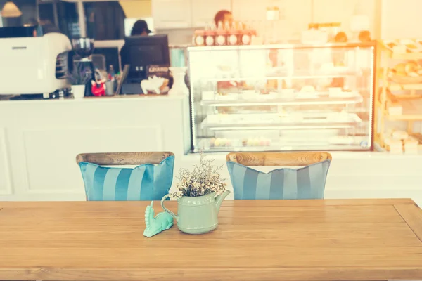Цветочный горшок на деревянном столе с размытым фоном кафе — стоковое фото