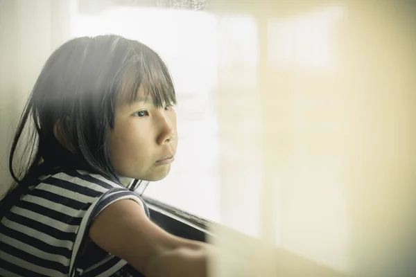 Asian girl looking out the window — Stock Photo, Image