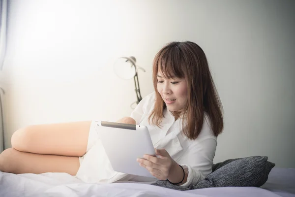 Asian woman laying on floor with tablet, lifestyle concept