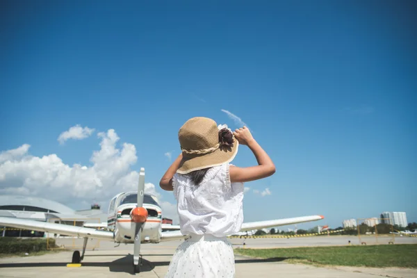 Lado de trás da menina olhando para o céu com pequeno avião backgr — Fotografia de Stock