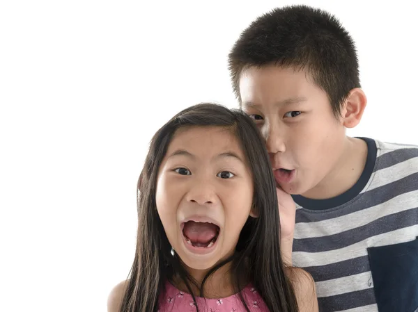 Asian boy telling girl a secret on white background with copyspa — Stockfoto