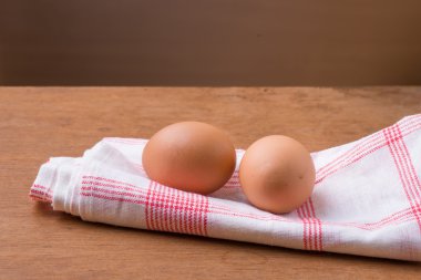 Ahşap masa ile kumaş üzerine yumurta.