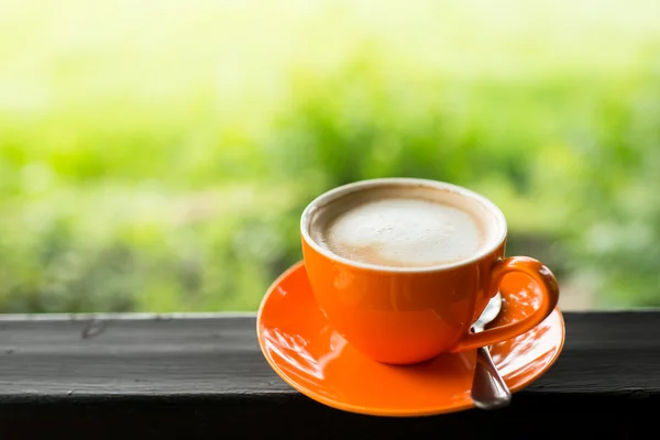 Tasse à café orange avec fond bokeh nature . — Photo