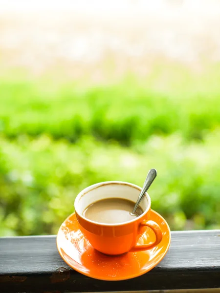 Orange Kaffeetasse mit Natur Bokeh Hintergrund. — Stockfoto