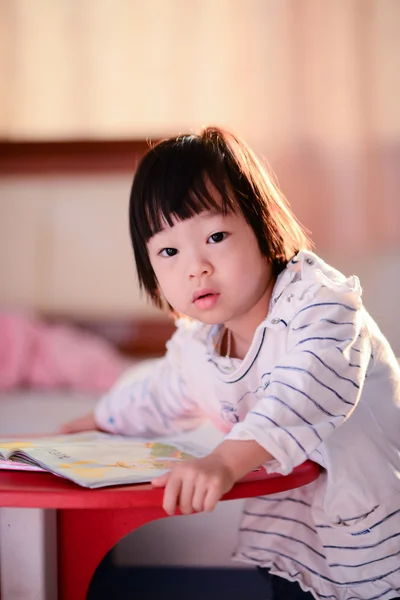 Menina asiática bonito ler um livro com luz borda natureza . — Fotografia de Stock