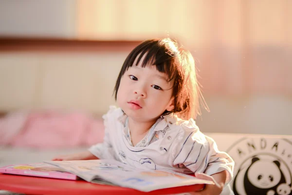 Cute Asian girl reading a book with nature rim light. — Stock Photo, Image