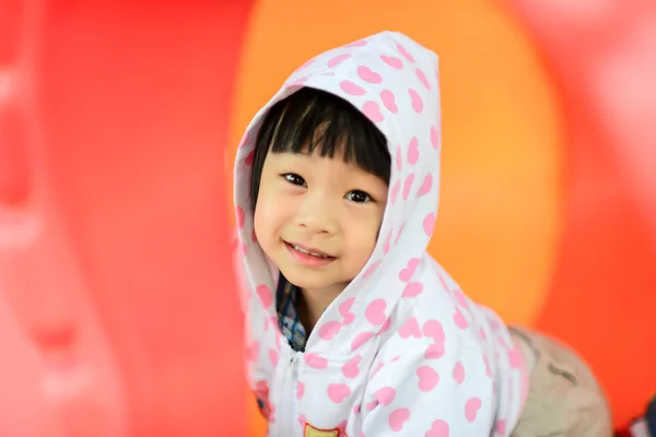 Asiática chica en blanco capucha chaqueta jugando en parque infantil . — Foto de Stock