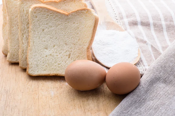 Pane e grano sullo sfondo di legno — Foto Stock